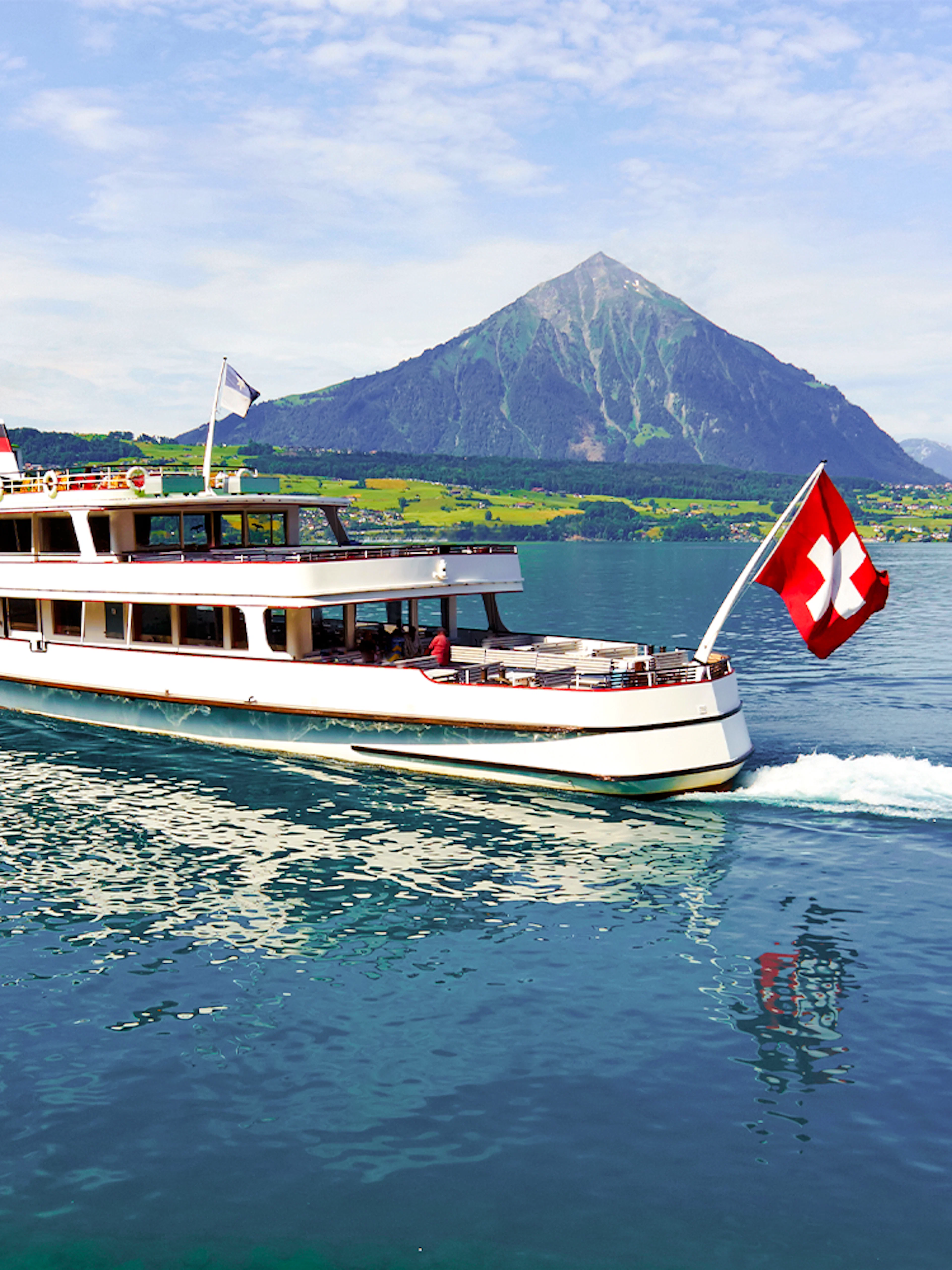 Passenger cruise boat on Lake Thun with Swiss flag, Switzerland.
