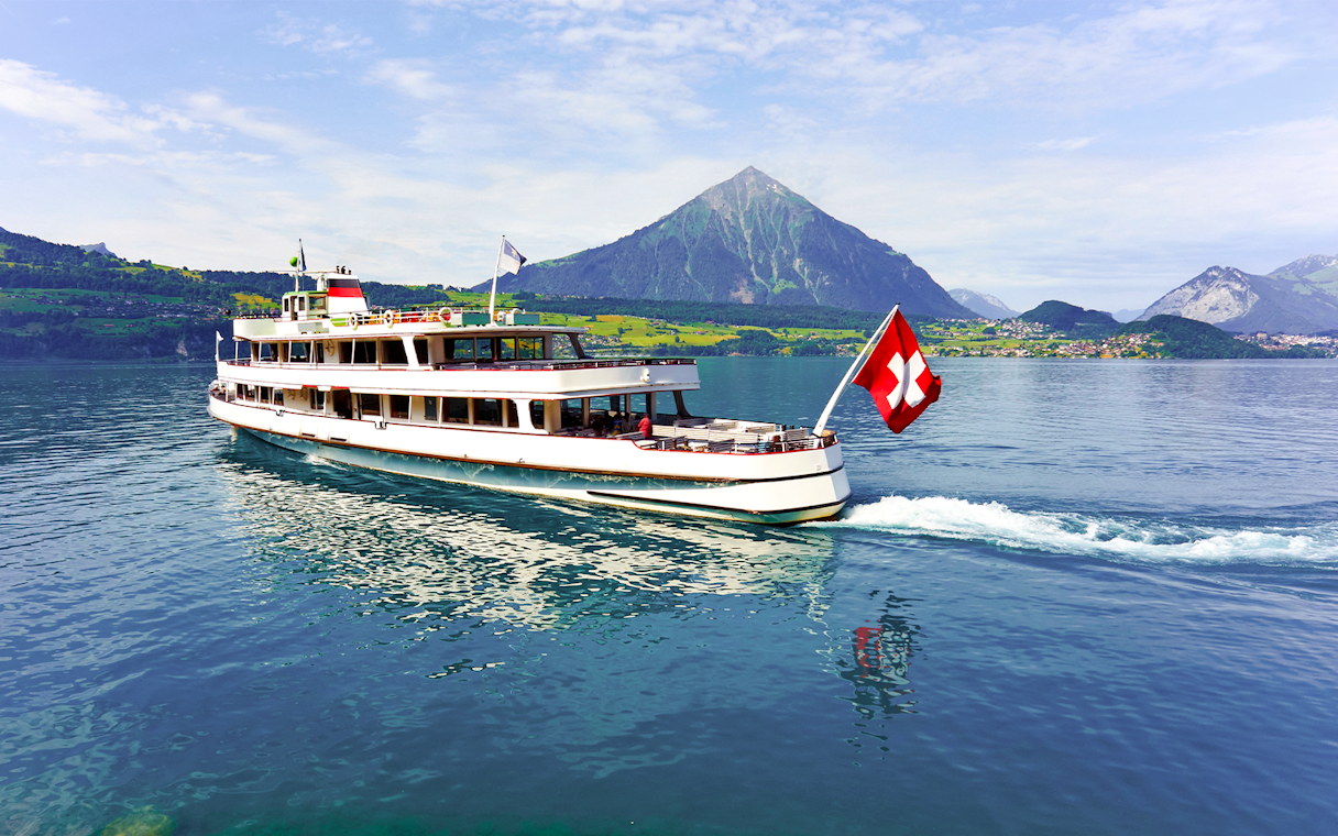 Passenger cruise boat on Lake Thun with Swiss flag, Switzerland.