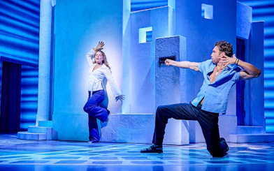 Actors performing a dance scene in Mamma Mia production.