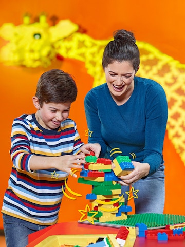 Child and adult building with LEGO bricks at LEGOLAND Discovery Centre Berlin.