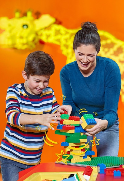 Child and adult building with LEGO bricks at LEGOLAND Discovery Centre Berlin.