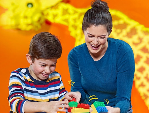 Child and adult building with LEGO bricks at LEGOLAND Discovery Centre Berlin.