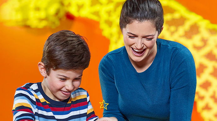 Child and adult building with LEGO bricks at LEGOLAND Discovery Centre Berlin.