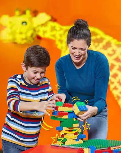 Child and adult building with LEGO bricks at LEGOLAND Discovery Centre Berlin.