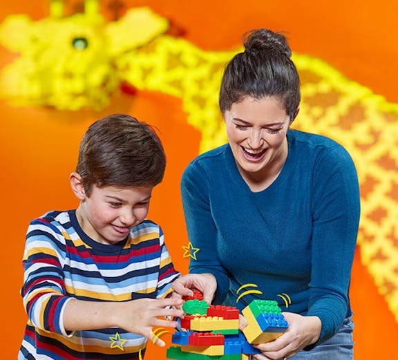 Child and adult building with LEGO bricks at LEGOLAND Discovery Centre Berlin.