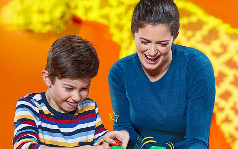 Child and adult building with LEGO bricks at LEGOLAND Discovery Centre Berlin.
