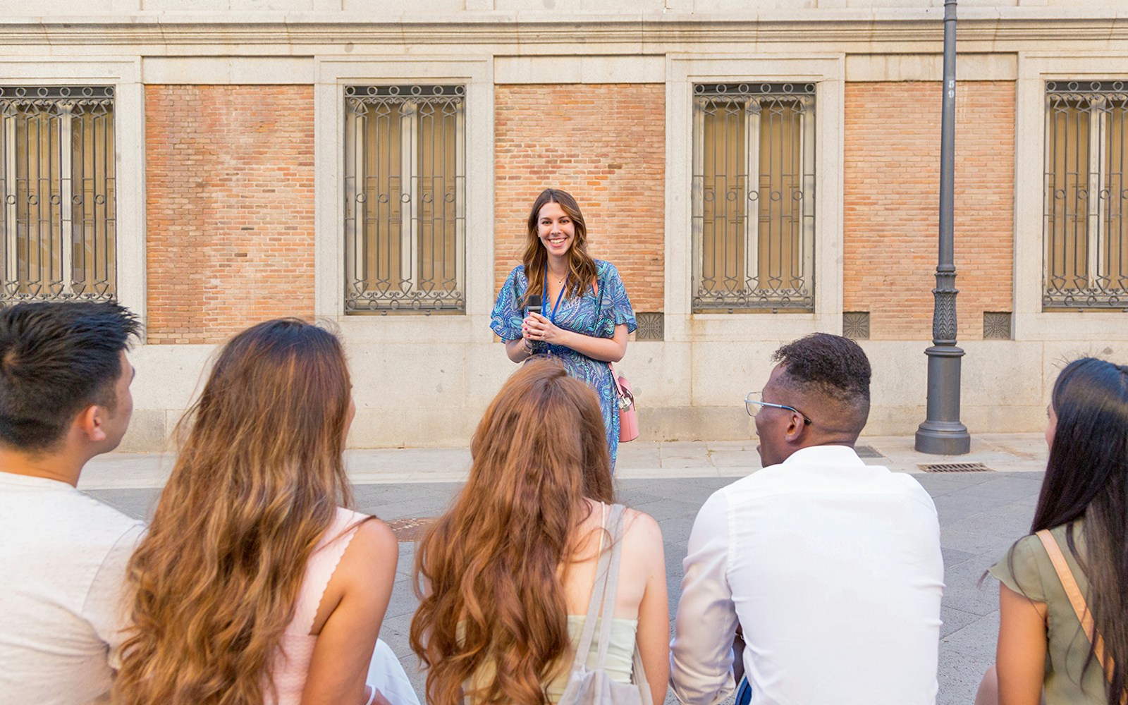 Tour guide briefing visitors in front of a historic building.
