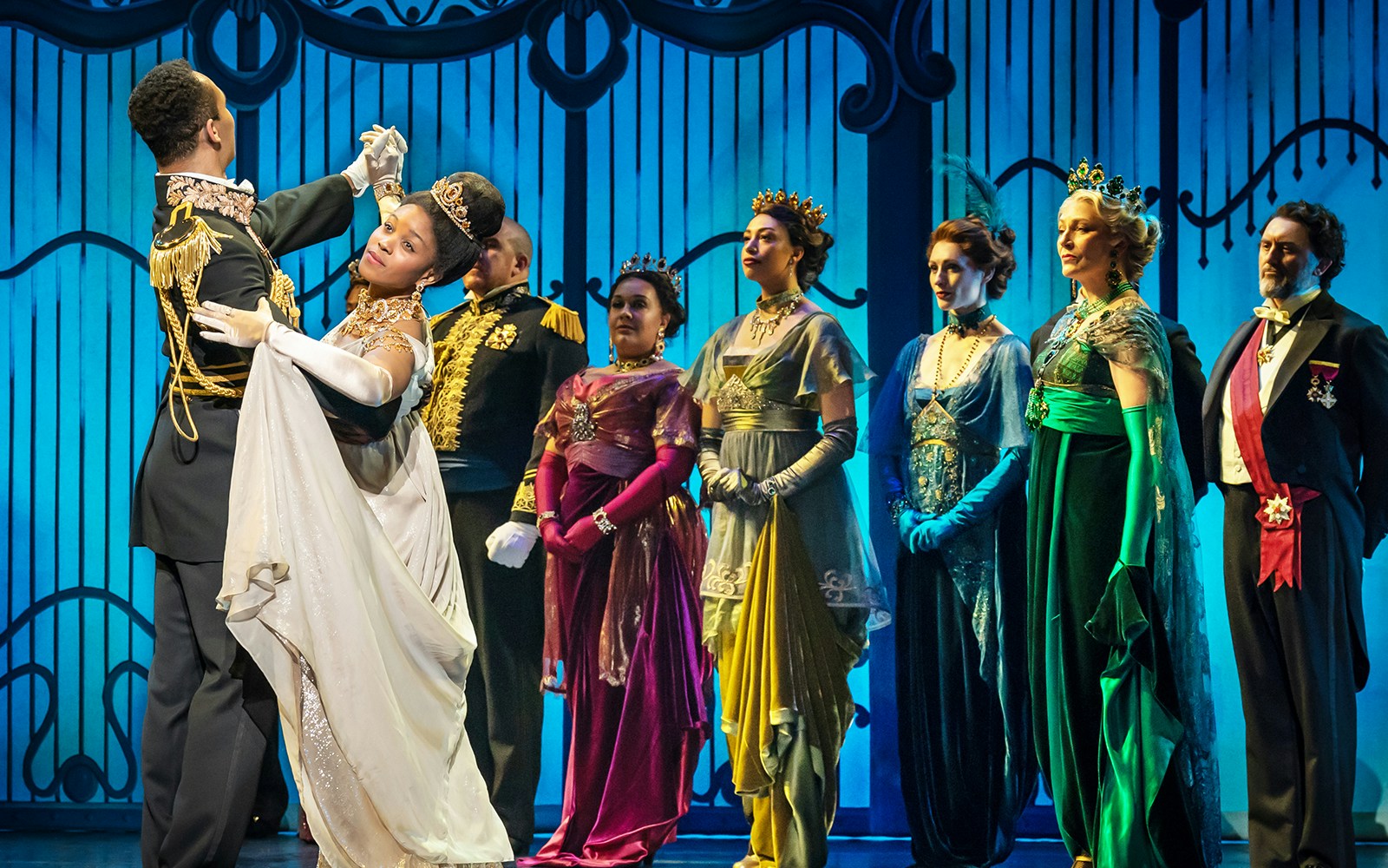 Dancers in elegant costumes performing a ballroom scene from My Fair Lady.