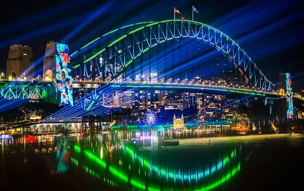 Sydney Harbour Bridge illuminated during Vivid Sydney cruise.