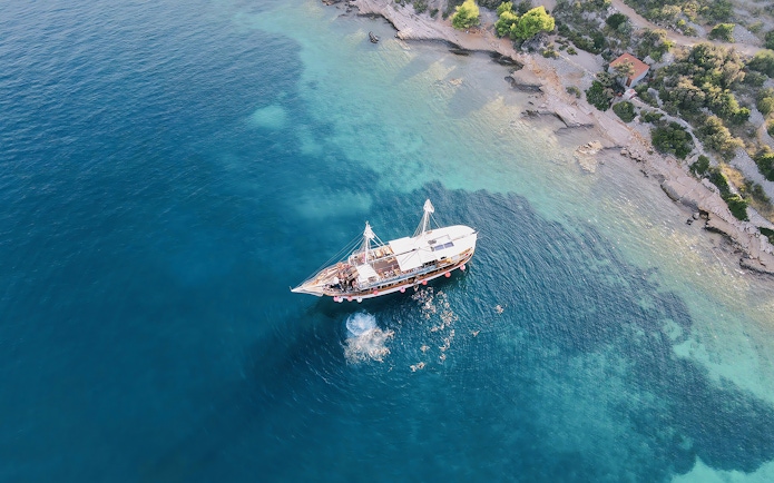 Boat party at Blue Lagoon, Split, Croatia with people swimming nearby.