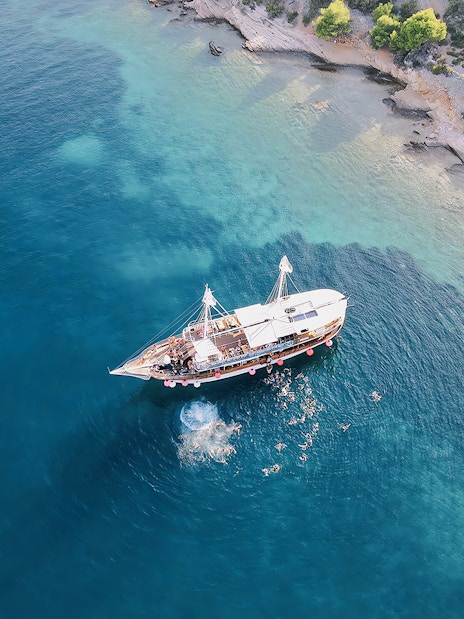 Boat party at Blue Lagoon, Split, Croatia with people swimming nearby.