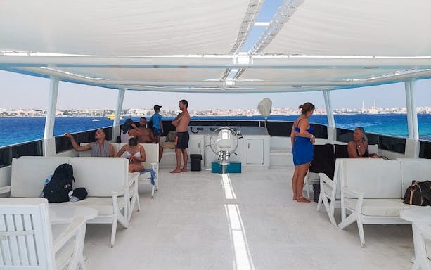 People relaxing on a boat deck during a full-day tour in Hurghada, Egypt.