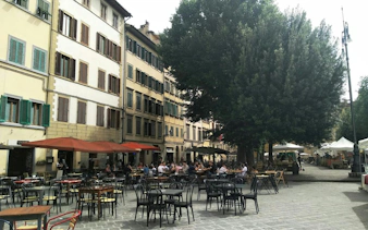 Outdoor café seating in a Florence square, part of the Detective Mystery self-guided city exploration game.