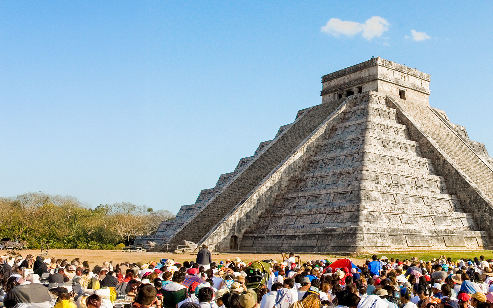 Crowd gathered at Chichen Itza during equinox, observing serpent shadow on pyramid.
