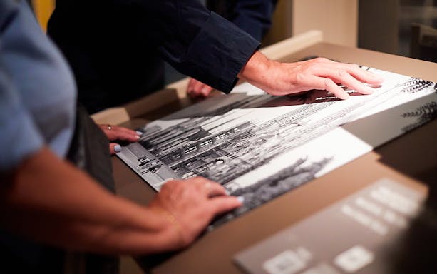 Hands exploring a tactile drawing of Sagrada Familia in Barcelona.