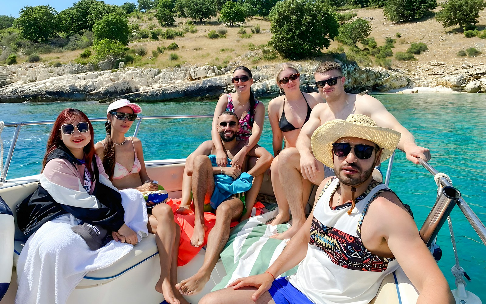 Group enjoying Saranda Boat Tour, Albania, with scenic coastline in the background.