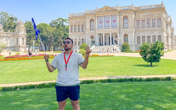 Tour guide leading a group in front of Dolmabahce Palace, Istanbul.