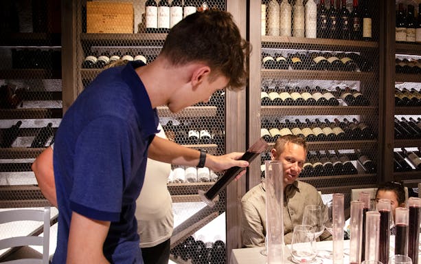 Wine tasting session in a Tuscan cellar with guests observing in Florence.
