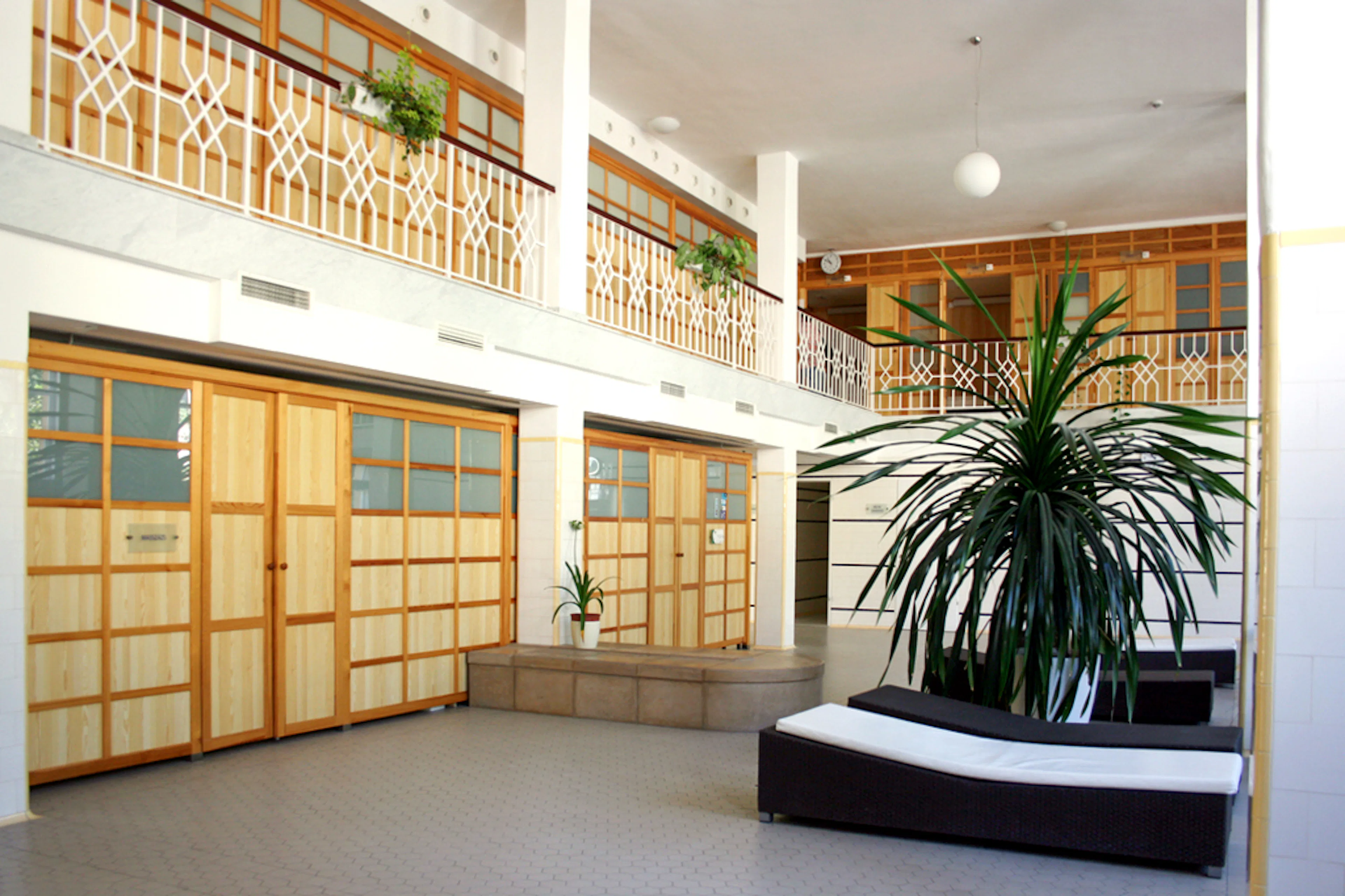 Lukacs Baths interior with wooden doors and large plant in Budapest, Hungary.