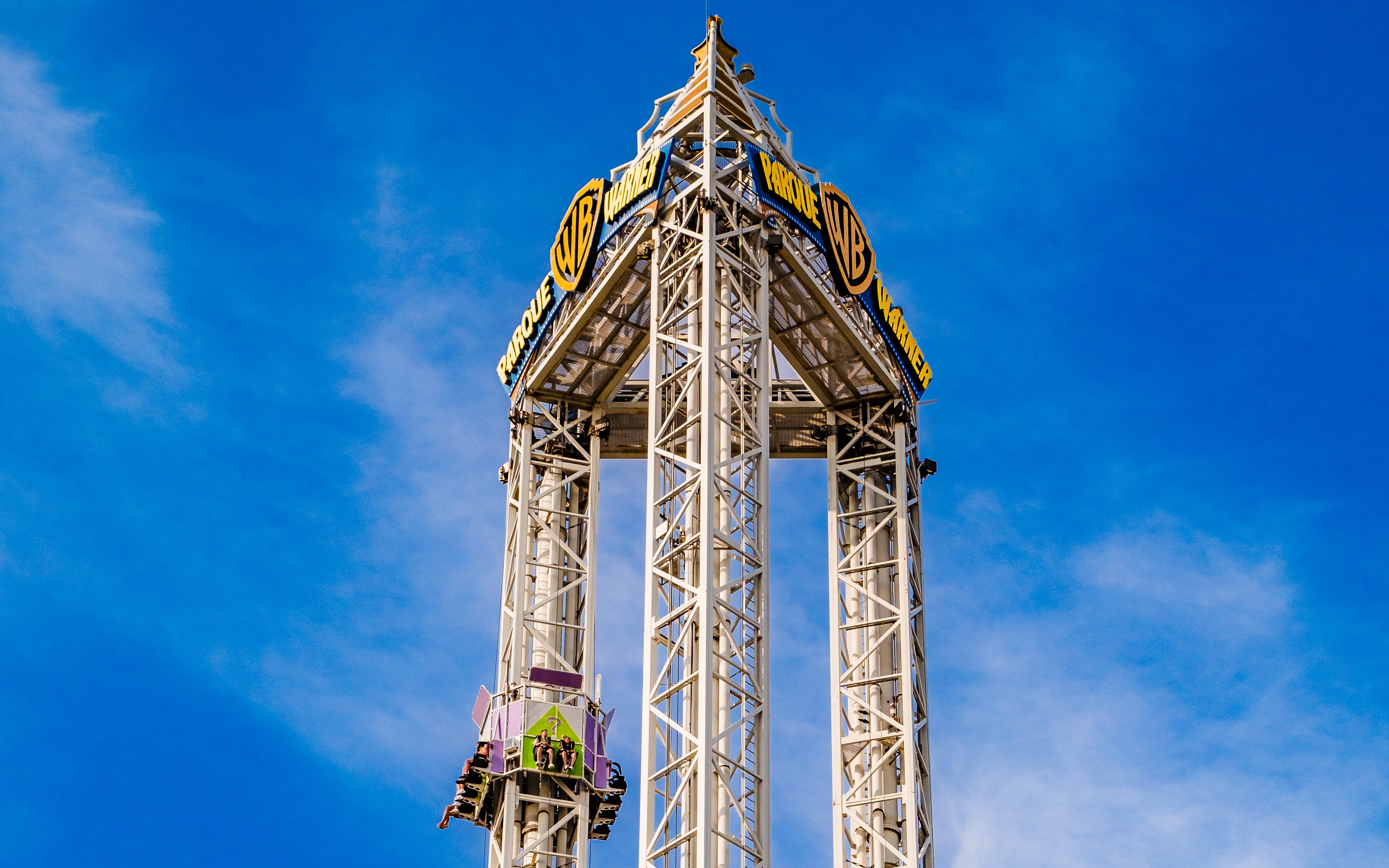 La Venganza del Enigma drop tower at Parque Warner Madrid against blue sky.