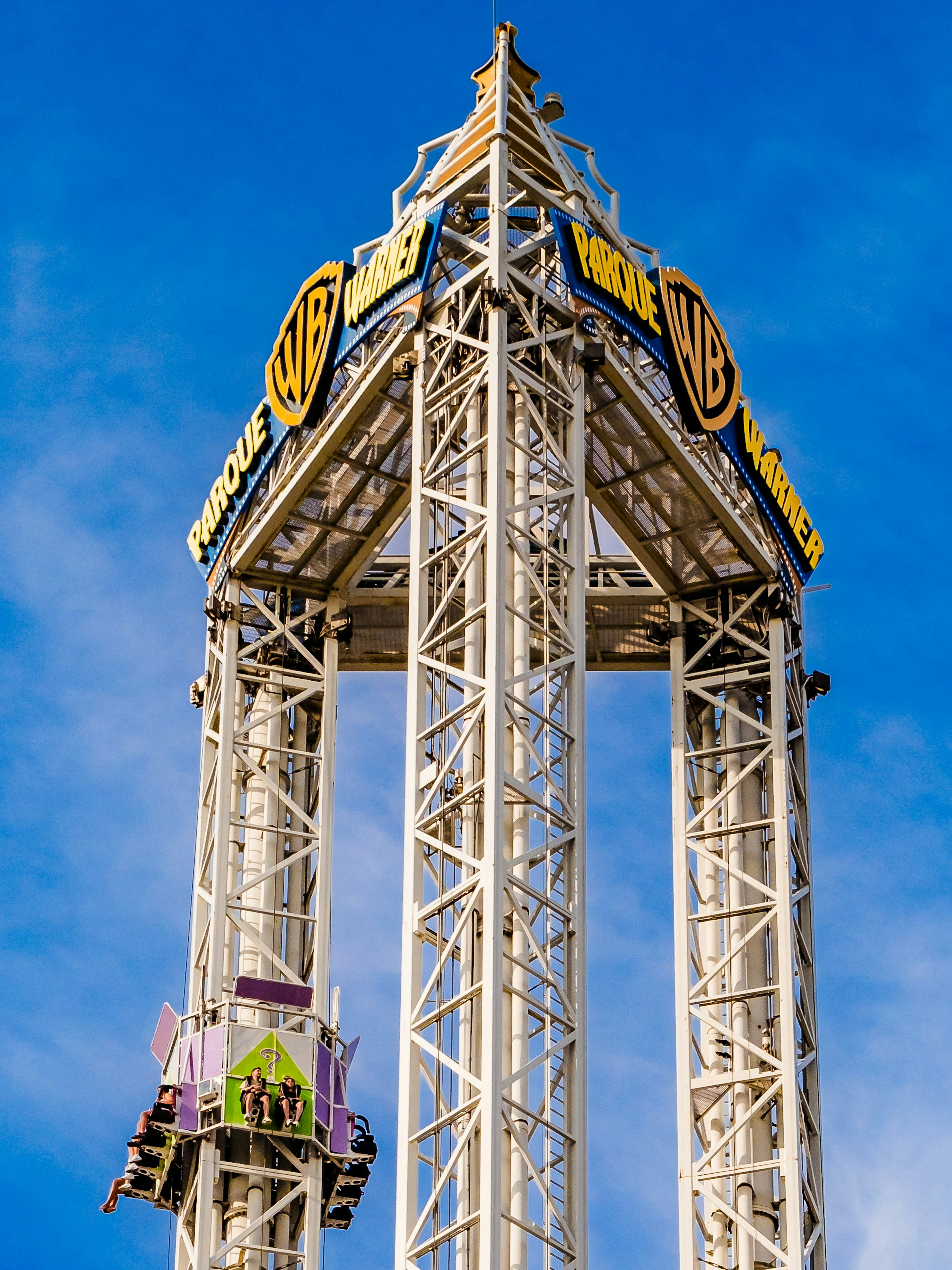 La Venganza del Enigma drop tower at Parque Warner Madrid against blue sky.