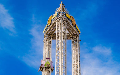 La Venganza del Enigma drop tower at Parque Warner Madrid against blue sky.