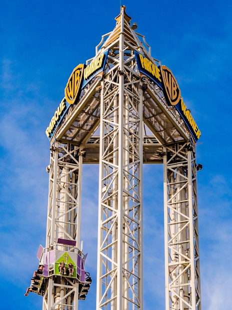 La Venganza del Enigma drop tower at Parque Warner Madrid against blue sky.