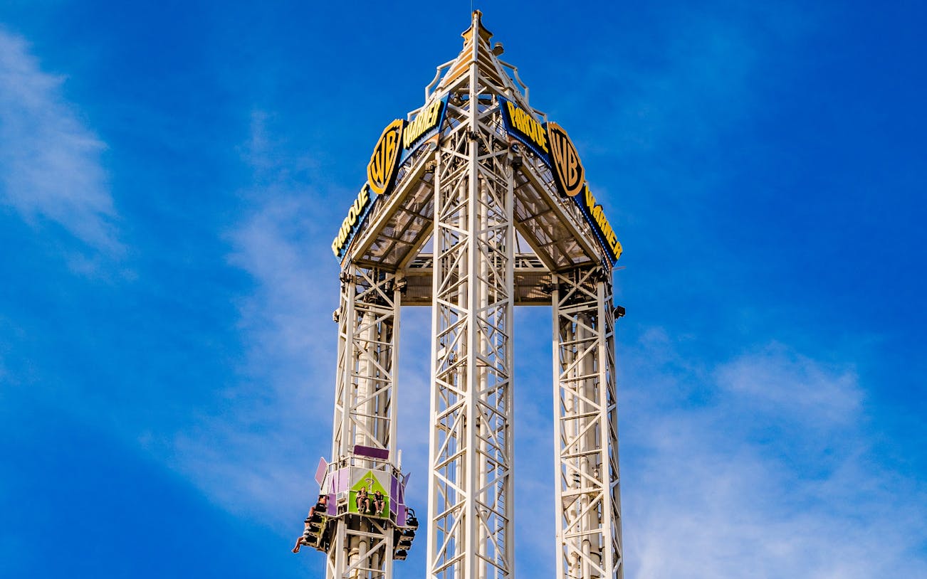 La Venganza del Enigma drop tower at Parque Warner Madrid against blue sky.