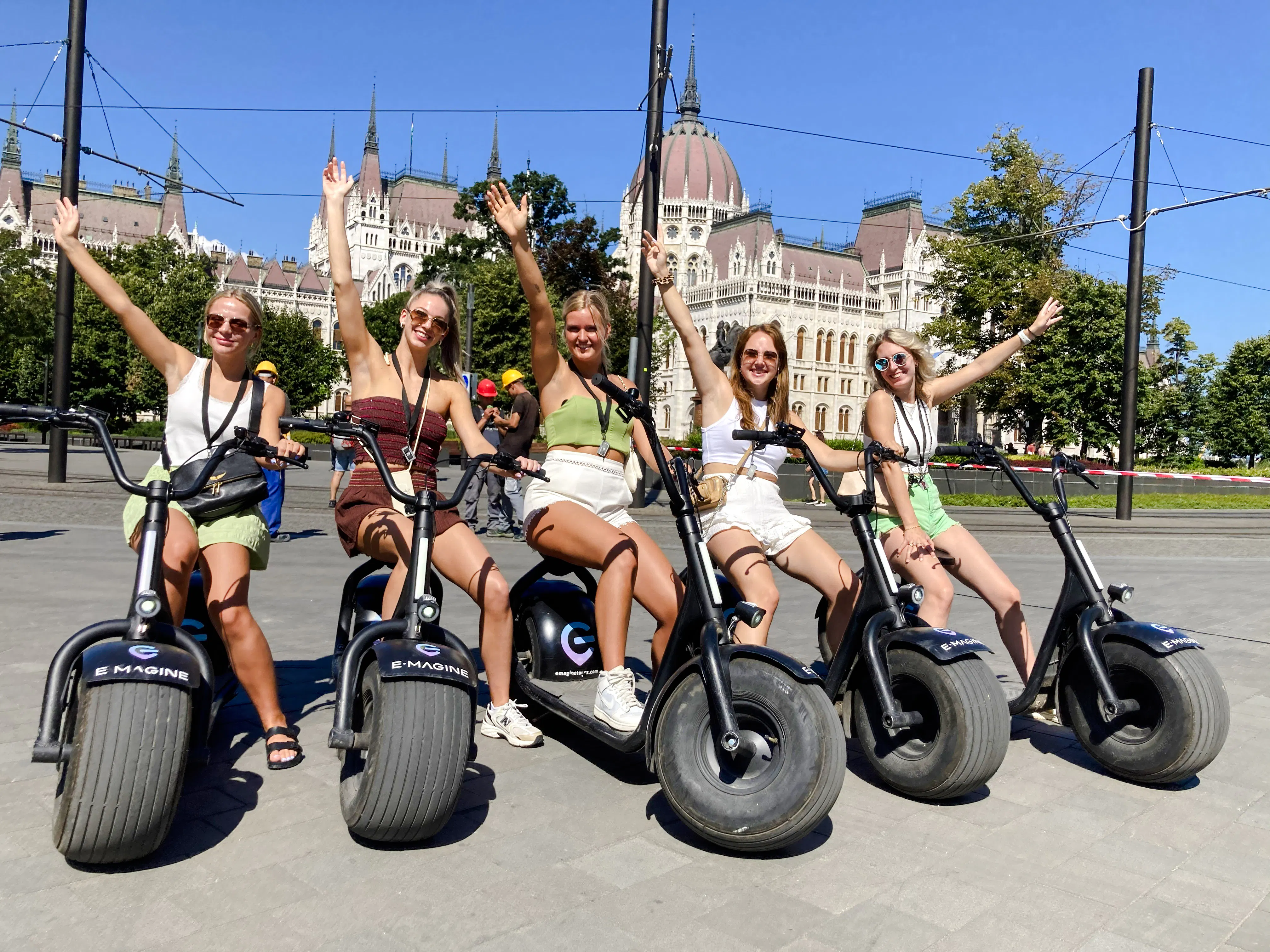 E-scooter riders in front of the Hungarian Parliament Building, Budapest.