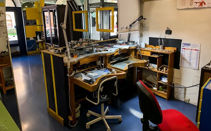 Jewelry workbench in Sardinian filigree workshop with tools and equipment.