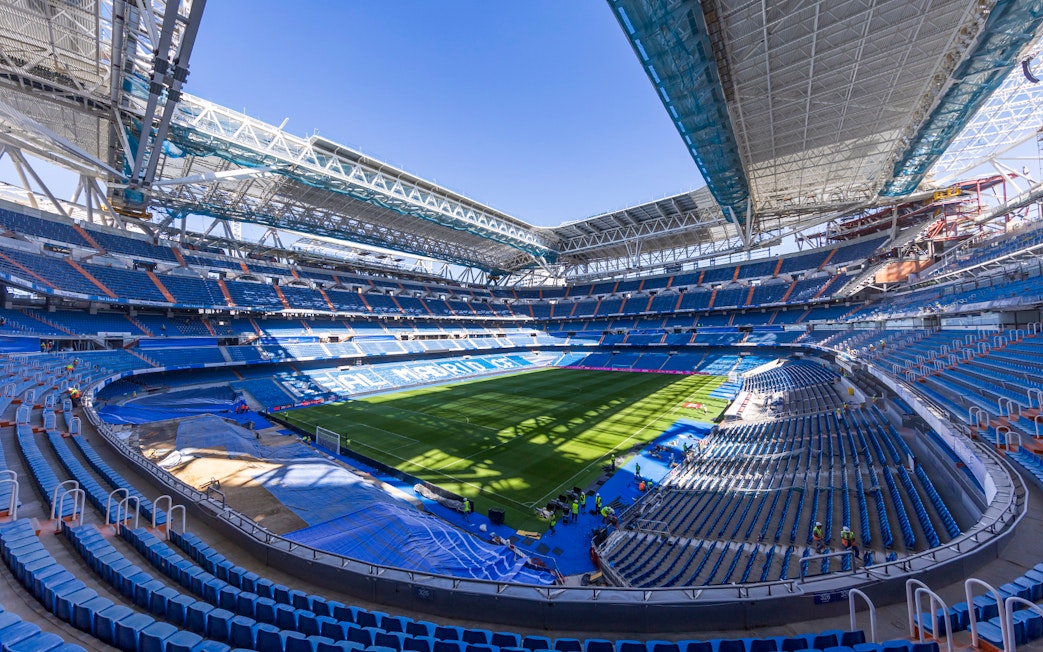 Santiago Bernabeu Stadium interior with empty seats and green field.