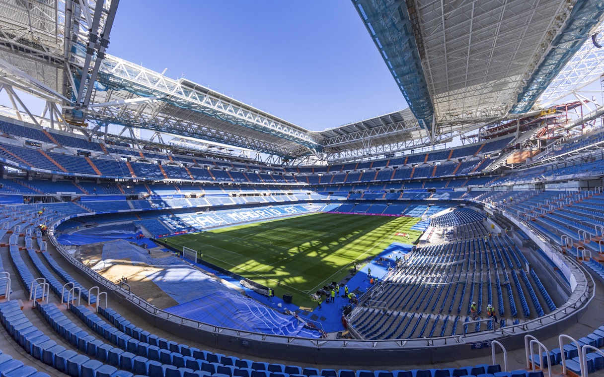 Santiago Bernabeu Stadium interior with empty seats and green field.
