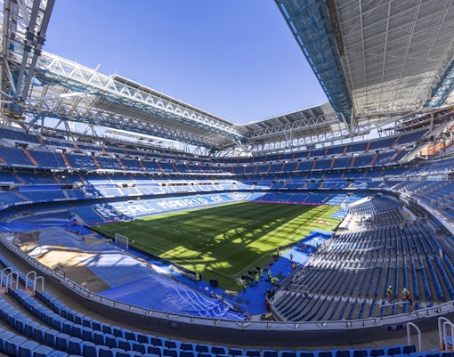 Santiago Bernabeu Stadium interior with empty seats and green field, Madrid.