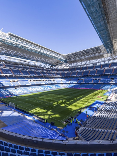 Santiago Bernabeu Stadium interior with empty seats and green field.