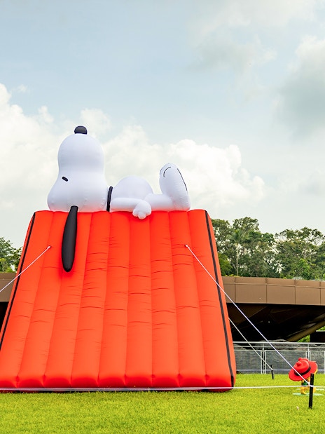Snoopy inflatable tent at Singapore Zoo with surrounding greenery.