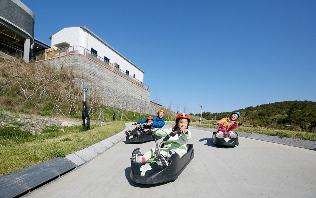People enjoying a luge ride at Skyline Luge Busan, South Korea.