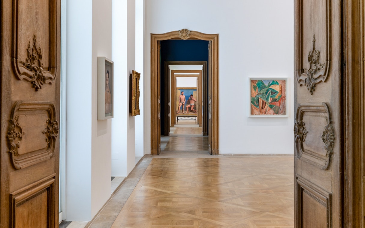 Picasso Museum hallway with framed artworks and ornate wooden doors.