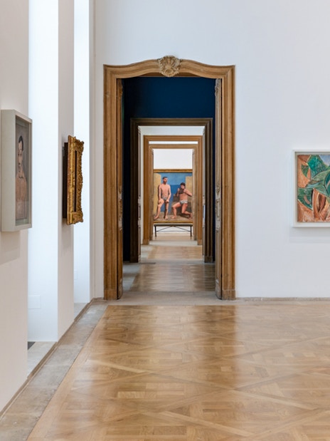Picasso Museum hallway with framed artworks and ornate wooden doors.