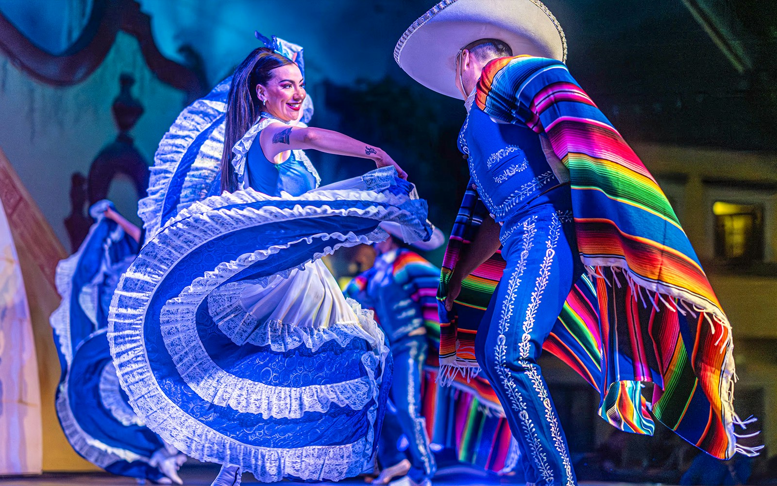 Dancers in traditional Mexican attire performing at Fiesta Mexicana show in Mexico City.
