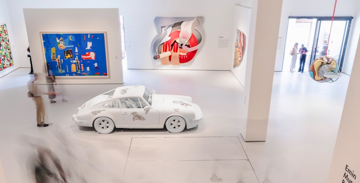 Interiors of Moco Museum London featuring modern art installations and a white car exhibit.