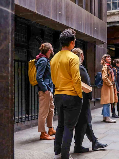 Tour group listening to a guide outside Simpsons in London on the Heart of 'The City' Food Tour.