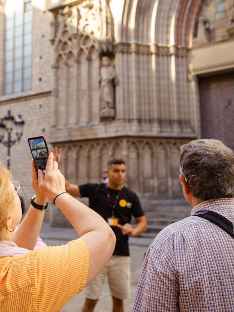 Tourists listening to a guide in front of a historic building in Barcelona.
