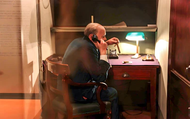 Man in historical office setting using a phone, part of Westminster Walking Tour & Churchill's War Rooms.