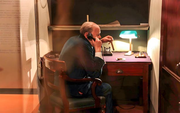 Man in historical office setting using a phone, part of Westminster Walking Tour & Churchill's War Rooms.