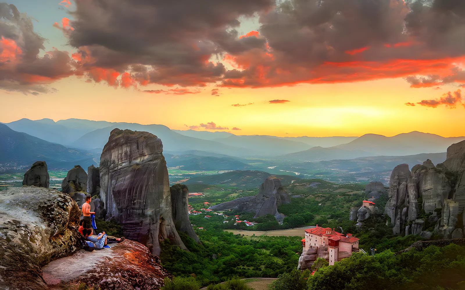Small group with guide watching sunset over Meteora rock formations in Greece.