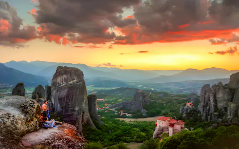Small group with guide watching sunset over Meteora rock formations in Greece.