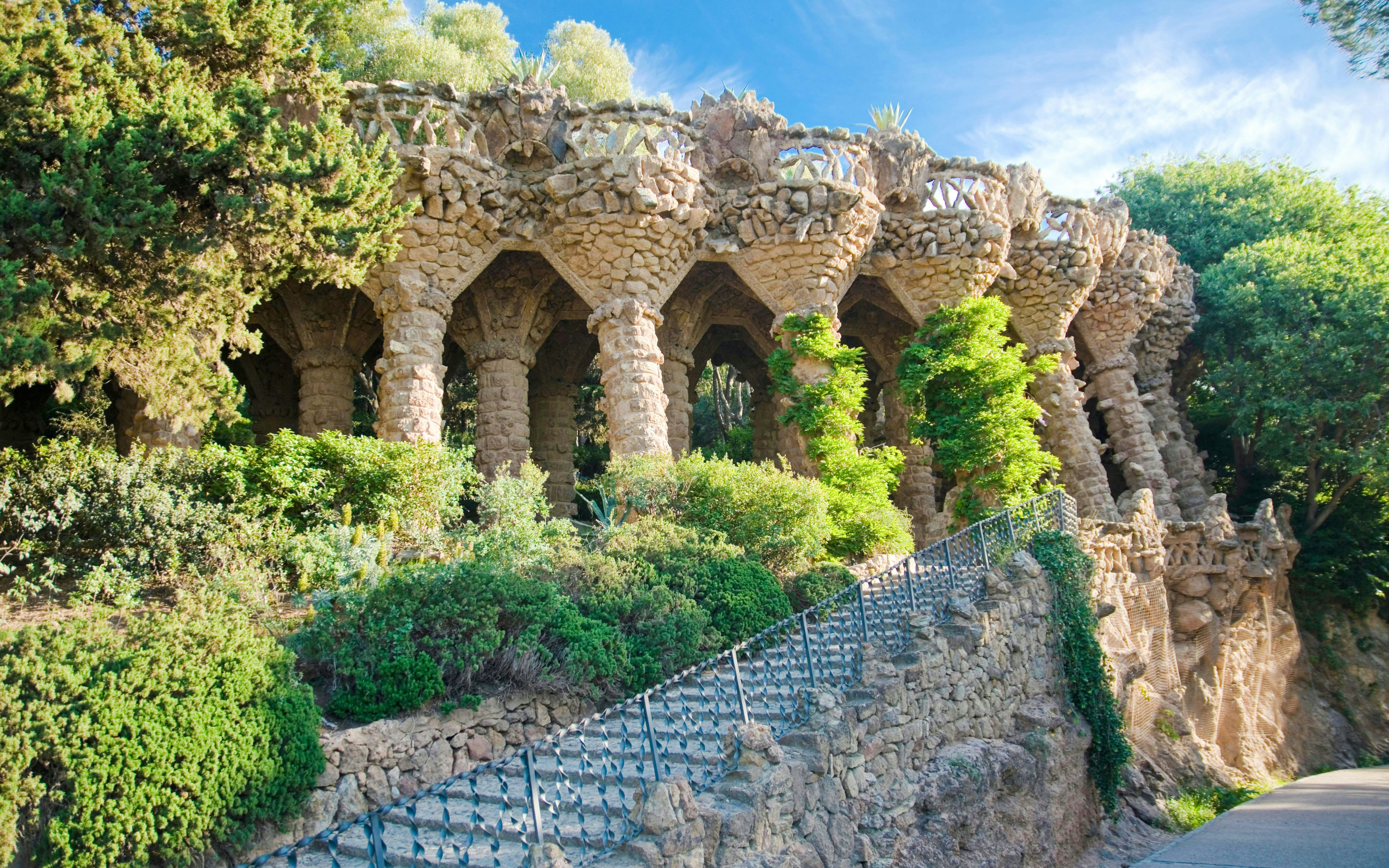 Park Guell stone viaducts surrounded by lush greenery in Barcelona.