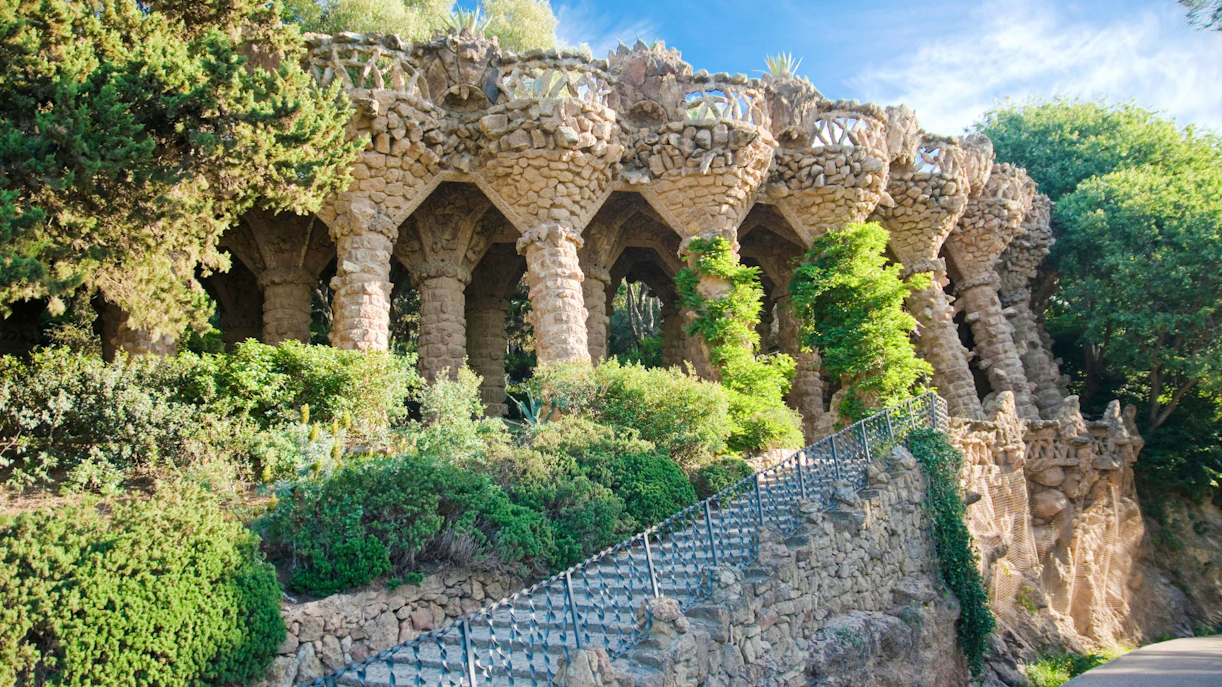 Park Guell stone viaducts surrounded by lush greenery in Barcelona.