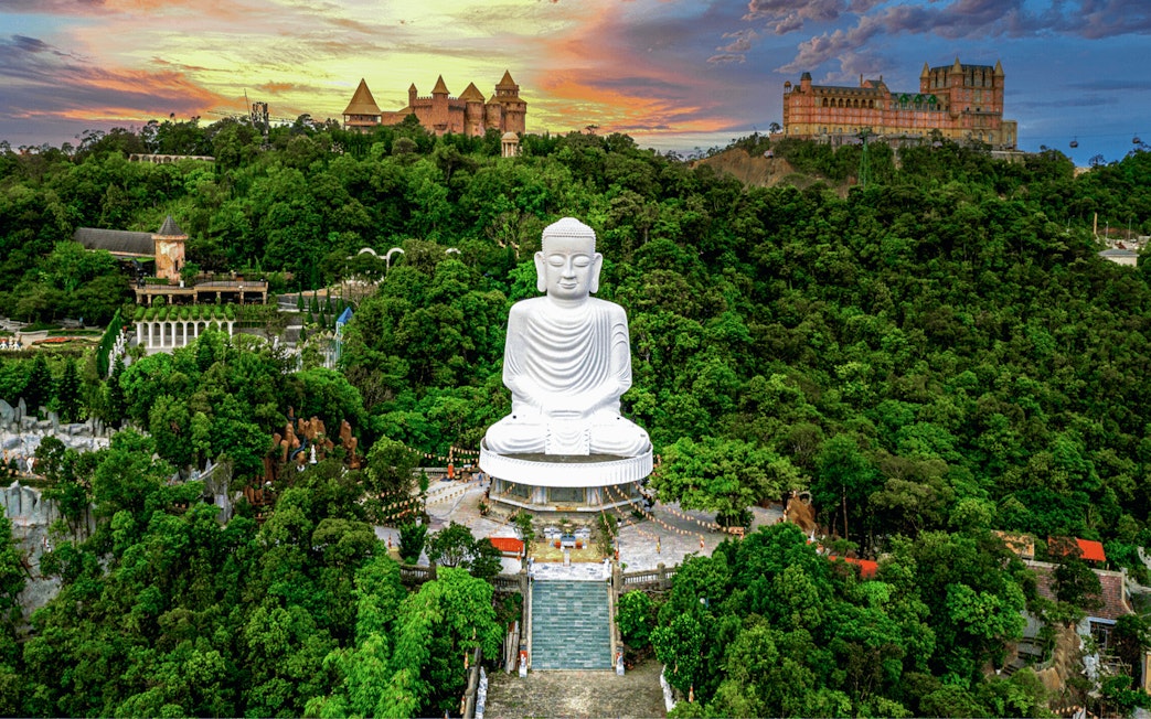 Aerial view of Buddha statue surrounded by lush greenery at Bana Hills, Da Nang, Vietnam.