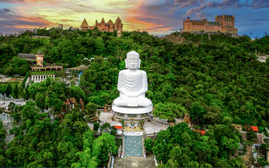 Aerial view of Buddha statue surrounded by lush greenery at Bana Hills, Da Nang, Vietnam.